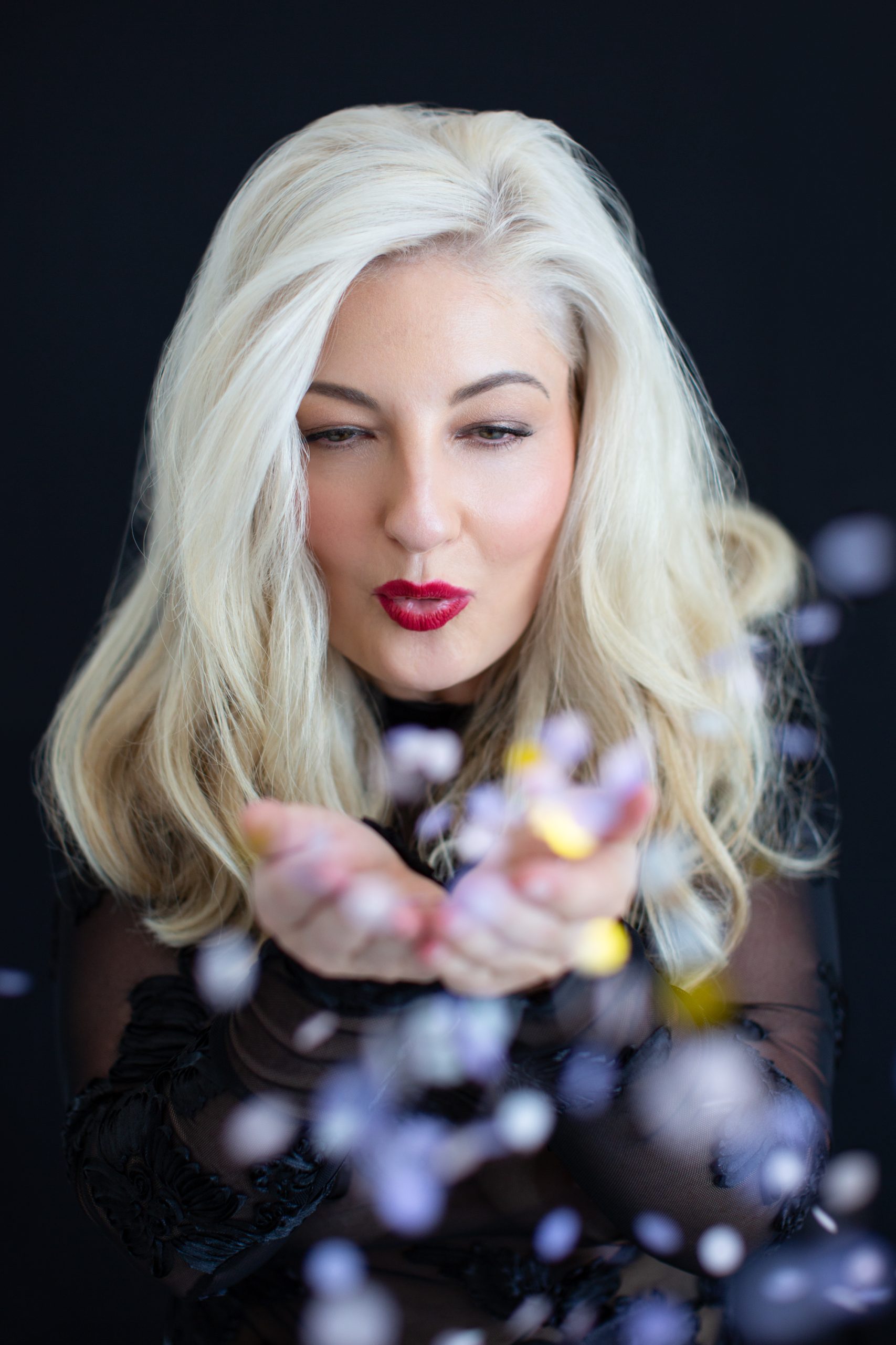 Elzabie Scott, relationship coach for women, blowing confetti during her personal brand photoshoot 